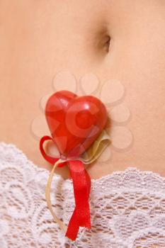 Woman's belly with red heart