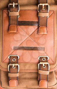 A closeup of brown leather bag buckle