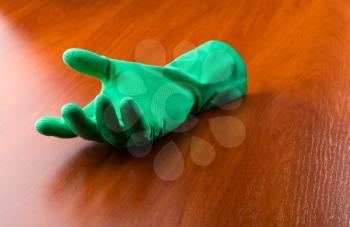 Green cleaning glove on the wooden table