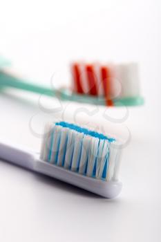 A closeup of two toothbrushes isolated on white background
