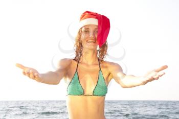 Tan smiling woman in christmas hat in sea 