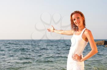 Smiling wet woman in white cloth inviting to sea