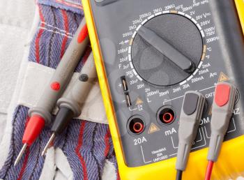 Close-up view of digital multimeter, probes and gloves