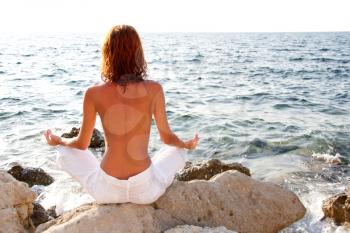 Woman meditating against the sea