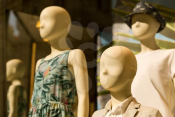 Female mannequins in dresses in th storefront
