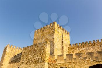 Tower and walls of an old castle agains blue sky