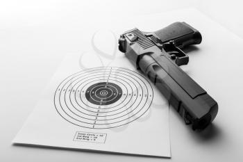 Paper target and pistol on white background