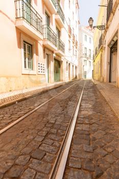 Tram rails on paved road on the narrow street
