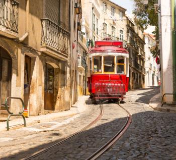 Old red tram on narrow european street in sunny days