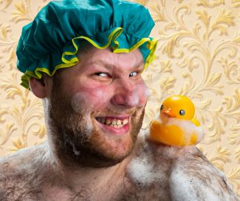 Happy man taking bath with duck toy