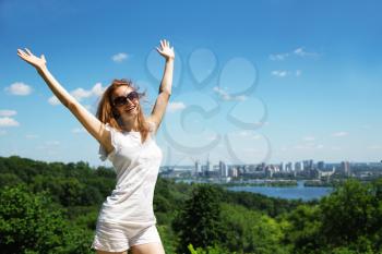 Excited young woman against cityscape