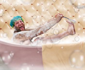 Bizarre ugly man washing his leg in a bath