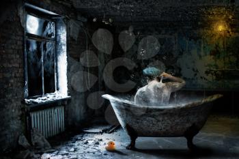 Alone sad man taking bath in abandoned room at night
