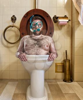 Bizarre man with goggles swimming in vintage toilet