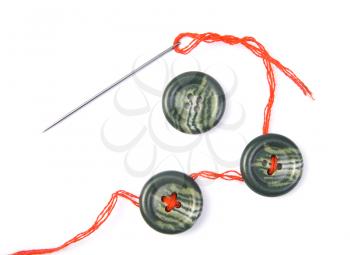 Sewing needle with red thread and buttons