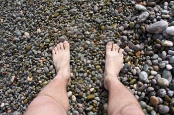 Man's legs on sea stones