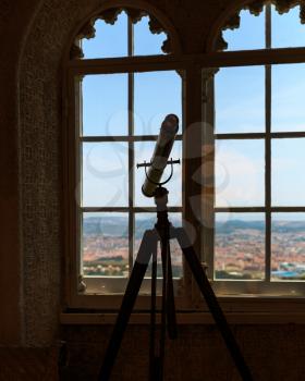 Telescope stands in the room near the window