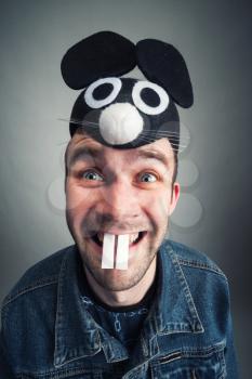 Portrait of strange young man with mouse ears and teeth 