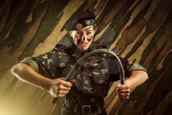 Strong army soldier woman is flexing an iron rod