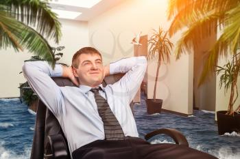 Businessman is dreaming about vacations in his office