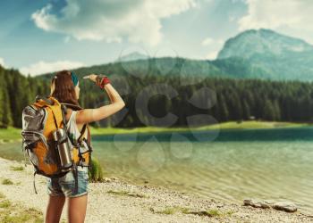 Traveler woman with backpack at the lake