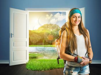 Happy traveler girl with backpack is standing against an opened doors to nature