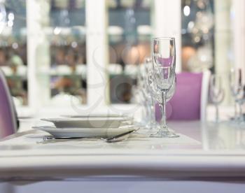 Served with a plates and glases on the table in white and purple colors
