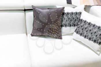 Leather pillows on the white sofa closeup