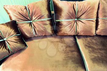 Velvet pillows on the brown sofa closeup