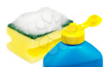 Bottle of a dishwashing liquid and sponge covered with foam