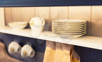 Picture of white plates and dinnerware in a cupboard.