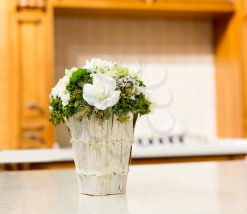 Beautiful bouquet of white rose flowers in basket on white table