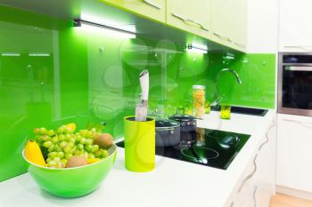 Modern green kitchen interior shot with fruits