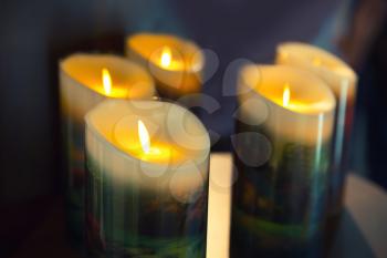 Burning candles on dark background, closeup
