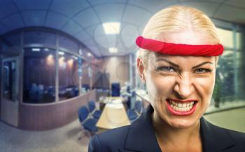 Furious businesswoman with a red bandage in the office