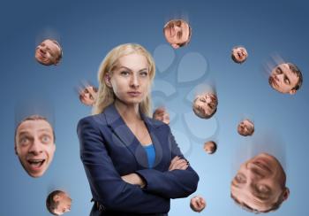 Serious businesswoman with man's head falling around