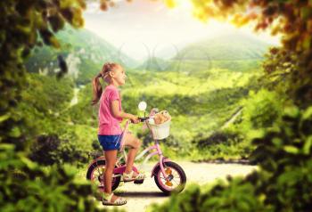Cute little girl cycling outdoors