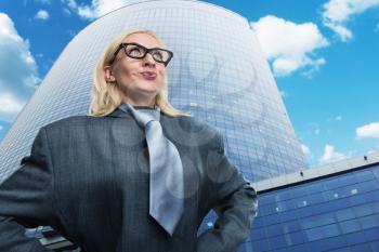 Surprised geek businesswoman near the skyscraper