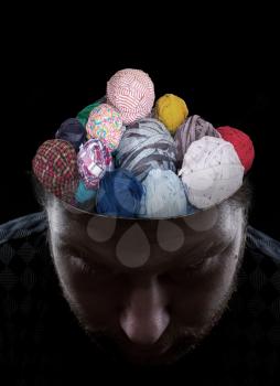 Young man with balls of threads instead of his brain 