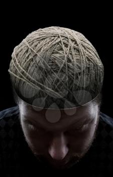 Young man with closed eyes and with balls of yarns instead of his brain 