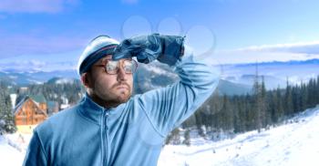 Retro skier in winter mountains looking at view