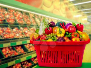 Heap of fresh vegetables in the basket against store shelves