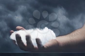 Human hand is holding a cloud