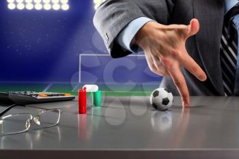 Businessman is playing small football with fingers on the table