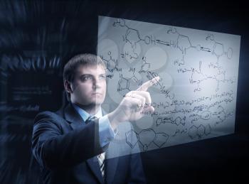 Businessman working with chemistry charts is thinking looking at the board