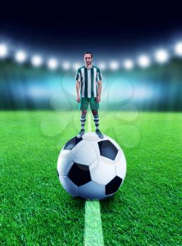 Football-player is standing on the ball