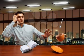 Businessman lifting objects in the air with magic