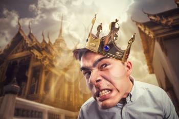 Crazy man wearing crown on the head over asian temple