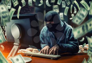 Hacker in mask stealing information and money in the office