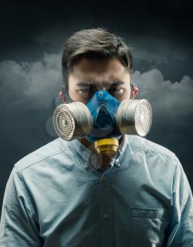 Young man in a gas-mask with atmospheric pollution